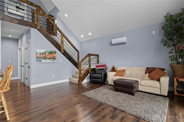 living room featuring wood finished floors, a towering ceiling, baseboards, an AC wall unit, and stairway