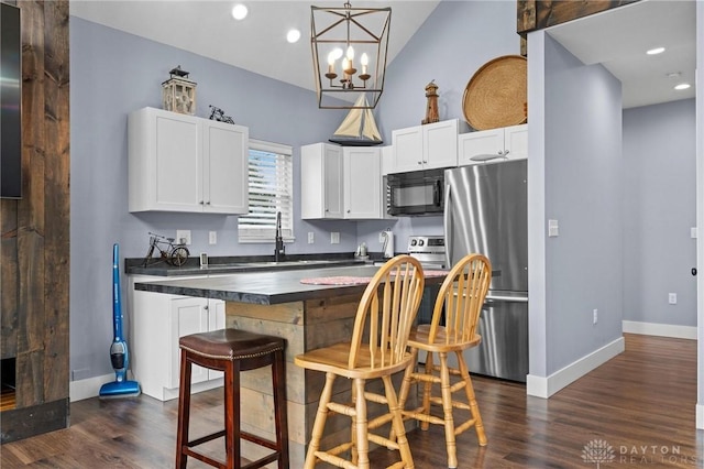 kitchen featuring sink, dark hardwood / wood-style floors, appliances with stainless steel finishes, white cabinetry, and a chandelier