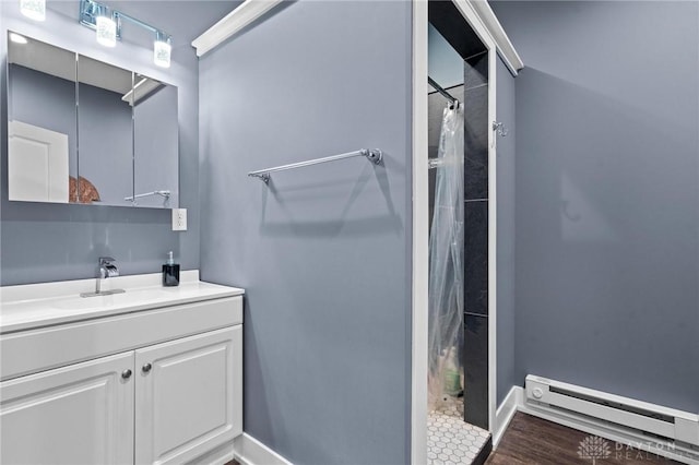 bathroom with vanity, wood-type flooring, baseboard heating, and walk in shower