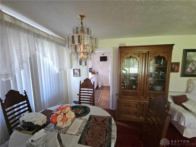 dining room with a notable chandelier and a textured ceiling