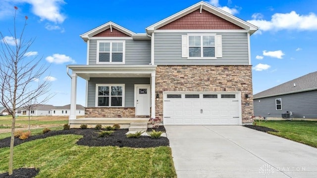 craftsman-style house with a front yard, a garage, and central air condition unit