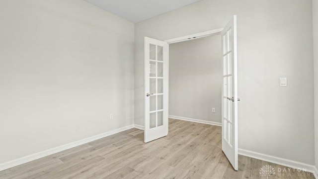 empty room featuring light wood-type flooring and french doors