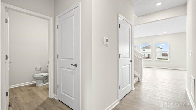 hallway with light hardwood / wood-style floors