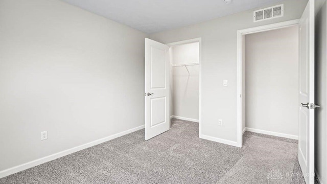 unfurnished bedroom with a closet and light colored carpet