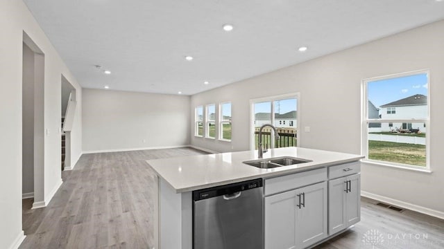 kitchen with dishwasher, a center island with sink, white cabinets, sink, and light hardwood / wood-style floors