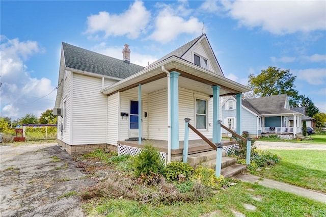 bungalow-style home featuring a front lawn and covered porch