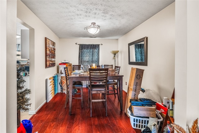 dining area with a textured ceiling and hardwood / wood-style floors