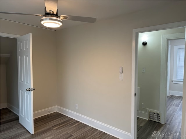 empty room with dark hardwood / wood-style floors and ceiling fan