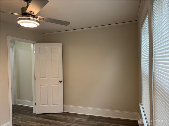 interior space with dark wood-type flooring, ceiling fan, and ornamental molding