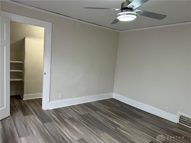 empty room featuring crown molding, dark hardwood / wood-style floors, and ceiling fan