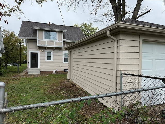 view of side of home featuring a yard and a garage