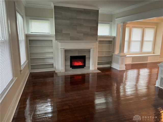 unfurnished living room featuring ornamental molding, a healthy amount of sunlight, a tile fireplace, and dark hardwood / wood-style flooring