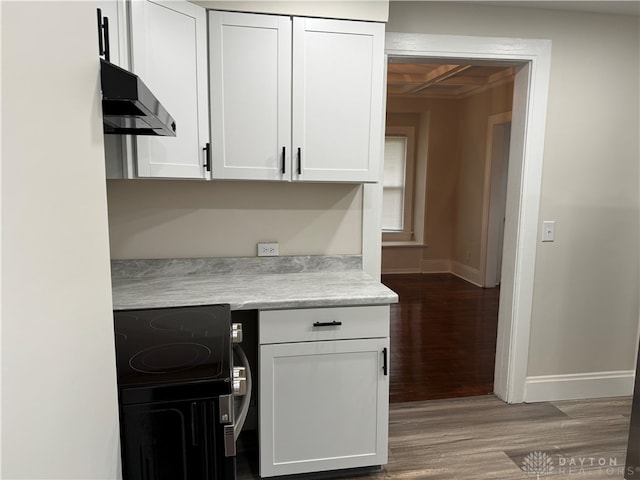 kitchen with range, white cabinets, and wood-type flooring