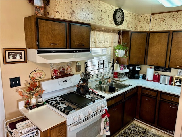 kitchen with dark brown cabinetry, sink, and gas range gas stove