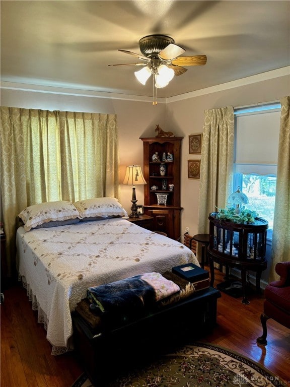 bedroom with ceiling fan, dark hardwood / wood-style flooring, and crown molding