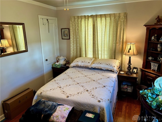 bedroom featuring crown molding, a closet, and dark wood-type flooring