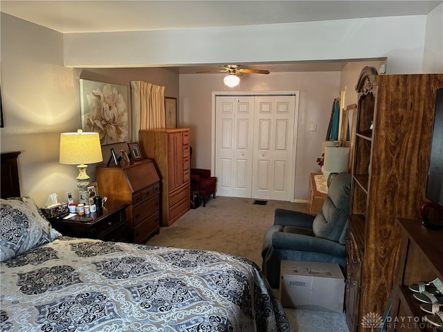 carpeted bedroom featuring ceiling fan and a closet