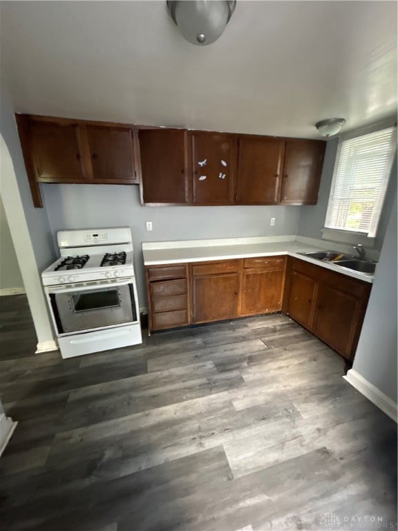 kitchen with hardwood / wood-style floors, sink, and white range with gas cooktop