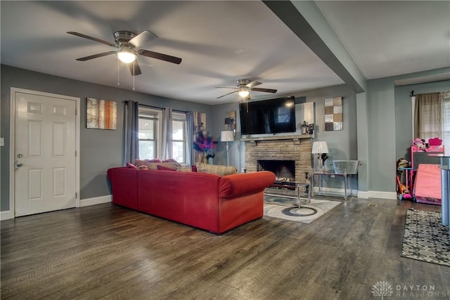 living room featuring a fireplace, dark hardwood / wood-style flooring, and ceiling fan