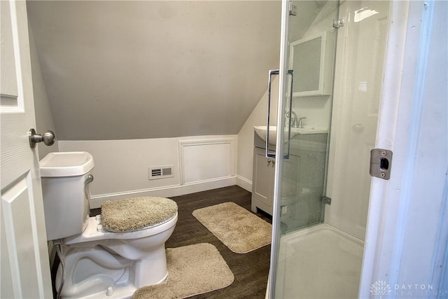 bathroom featuring hardwood / wood-style flooring, toilet, an enclosed shower, and vaulted ceiling