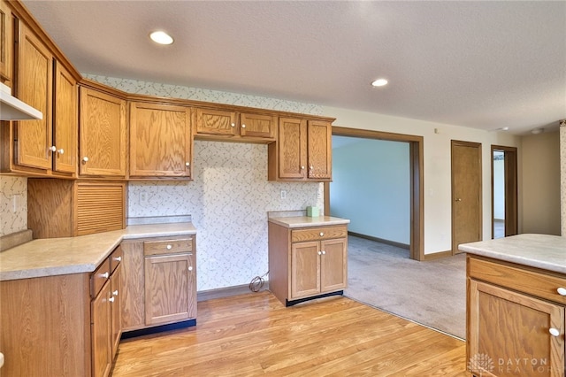 kitchen featuring light hardwood / wood-style floors and a textured ceiling