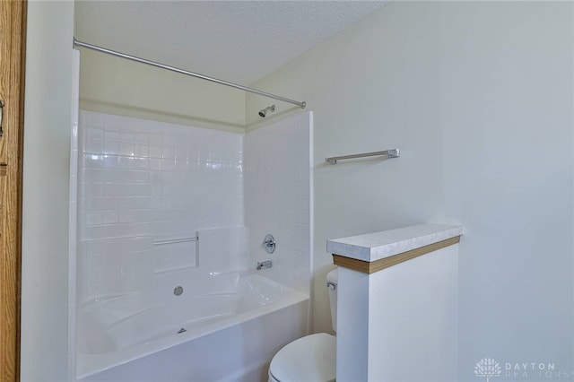 bathroom featuring bathing tub / shower combination, a textured ceiling, and toilet