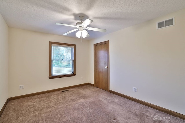 carpeted empty room with a textured ceiling and ceiling fan