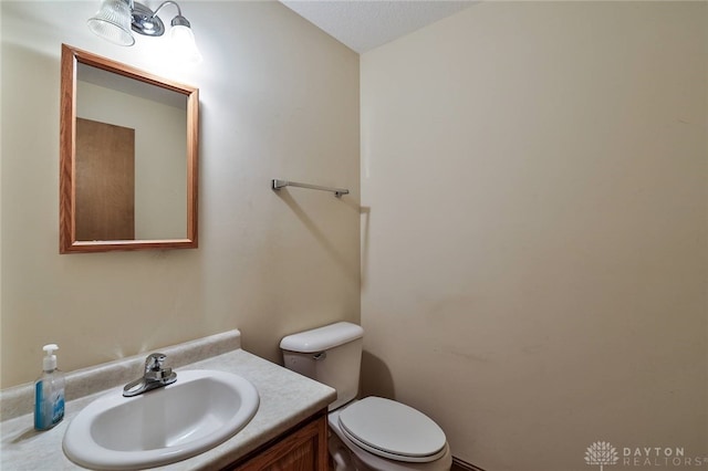 bathroom featuring vanity, a textured ceiling, and toilet