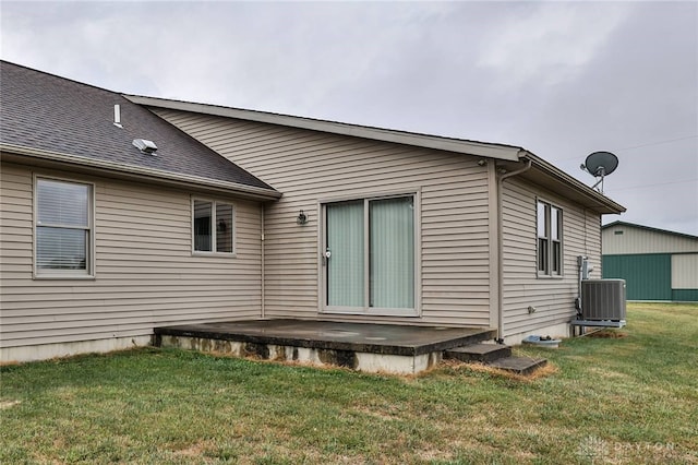 rear view of property featuring a patio, central AC unit, and a lawn