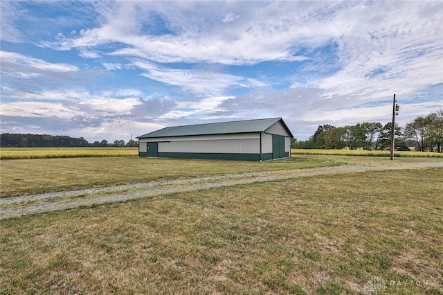 view of outdoor structure featuring a rural view and a yard