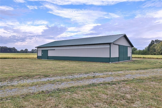 garage with a rural view and a yard