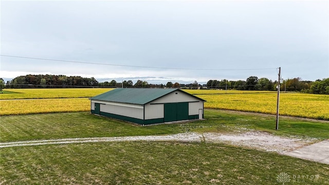 view of outdoor structure featuring a rural view and a yard