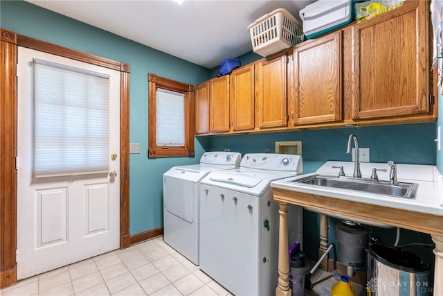 clothes washing area with independent washer and dryer, light tile patterned floors, and cabinets