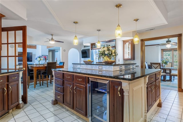 kitchen featuring wine cooler, dark brown cabinets, a center island, and light tile patterned flooring