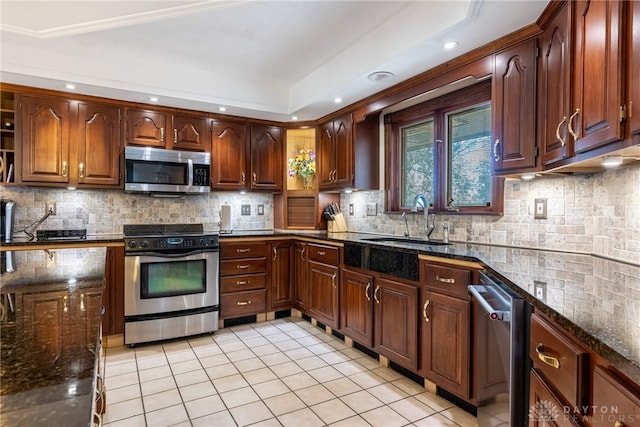 kitchen with appliances with stainless steel finishes, sink, light tile patterned floors, and backsplash