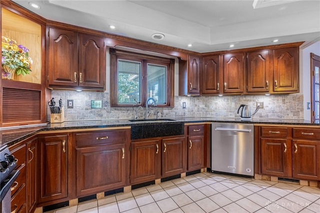 kitchen with sink, dark stone countertops, decorative backsplash, light tile patterned floors, and stainless steel appliances