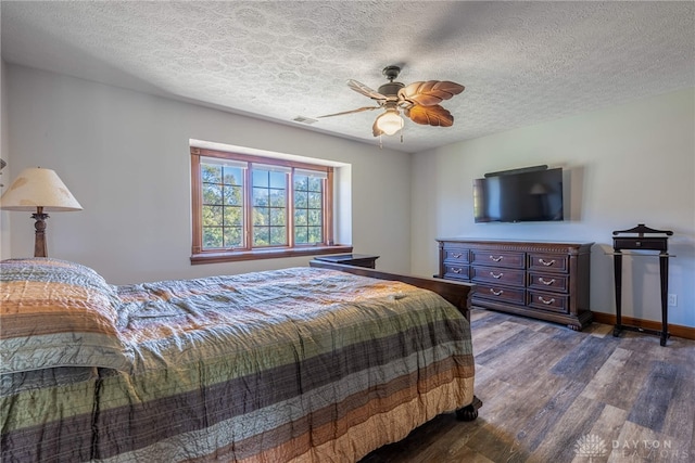 bedroom featuring dark wood-type flooring, ceiling fan, and a textured ceiling