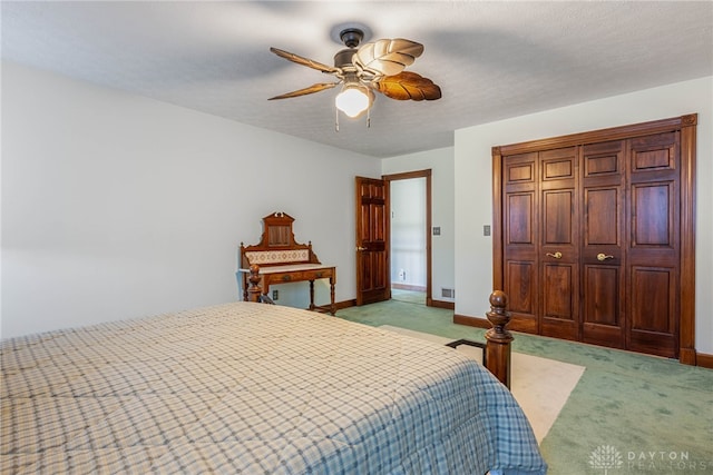 carpeted bedroom featuring ceiling fan and a textured ceiling