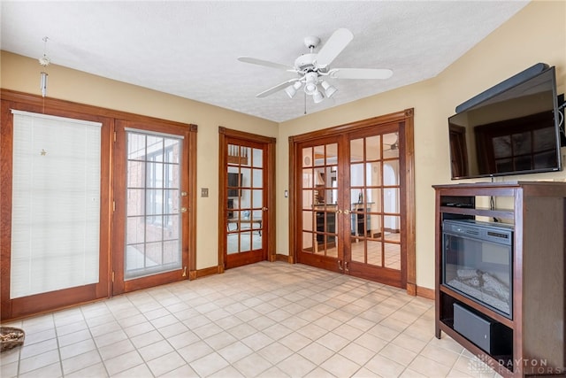 doorway with french doors, ceiling fan, and a textured ceiling