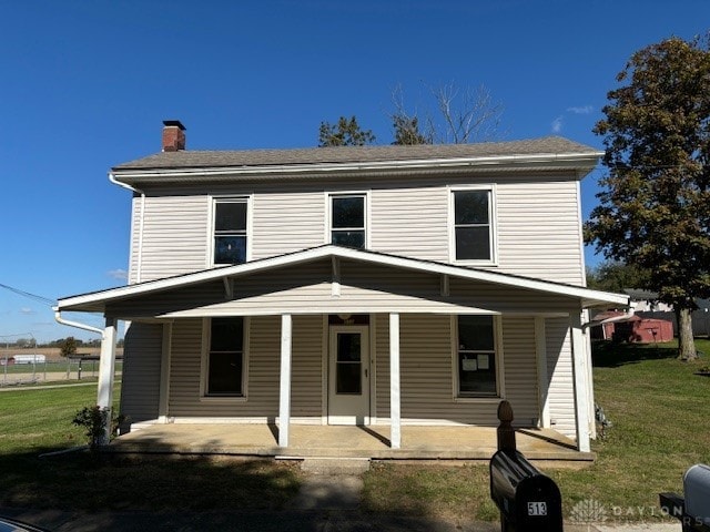 view of front of home with covered porch and a front lawn