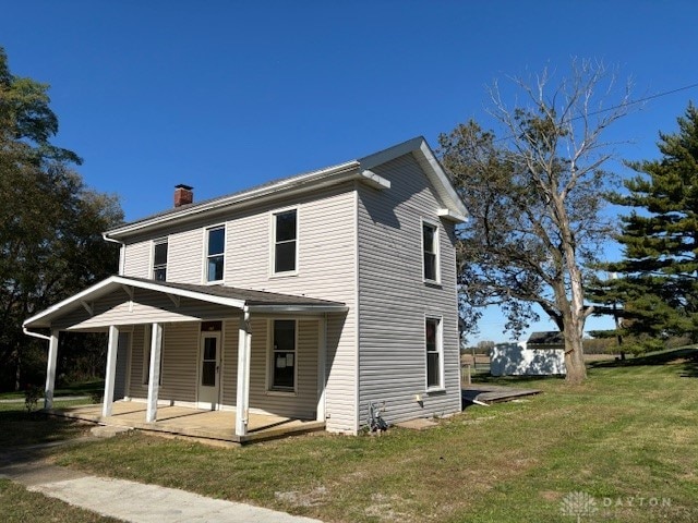 view of front of house with a patio and a front yard