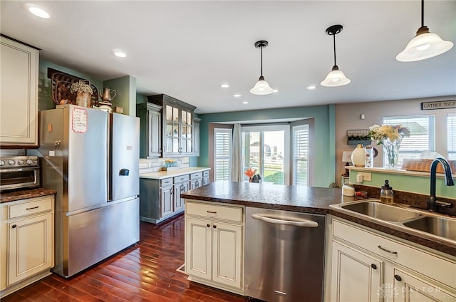 kitchen featuring stainless steel appliances, plenty of natural light, and cream cabinetry