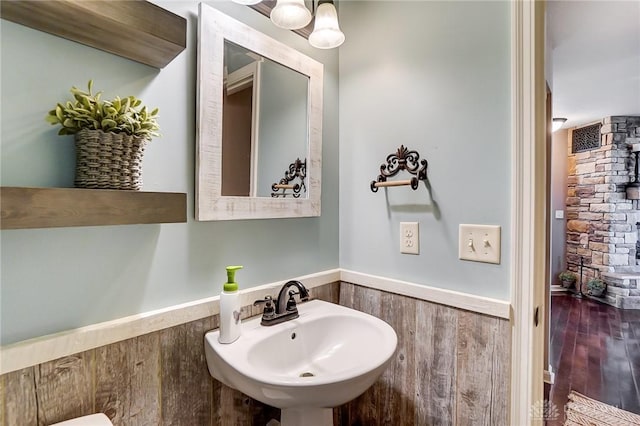 half bathroom featuring wood finished floors and a sink