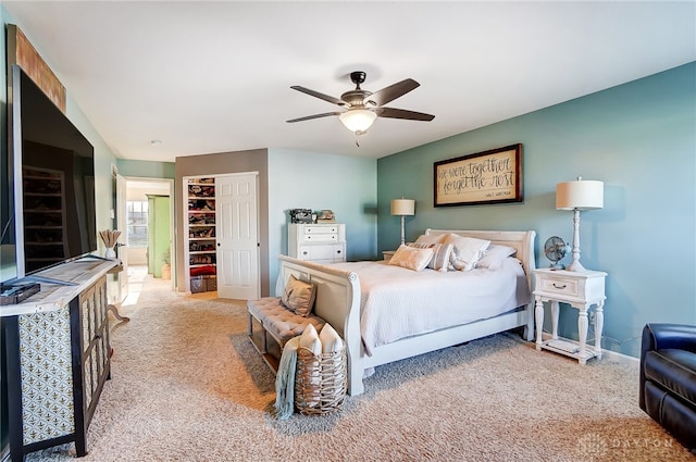 carpeted bedroom featuring a spacious closet, a closet, and ceiling fan