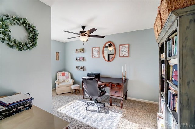 carpeted office with a ceiling fan and baseboards