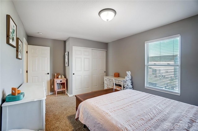 carpeted bedroom featuring a closet and baseboards