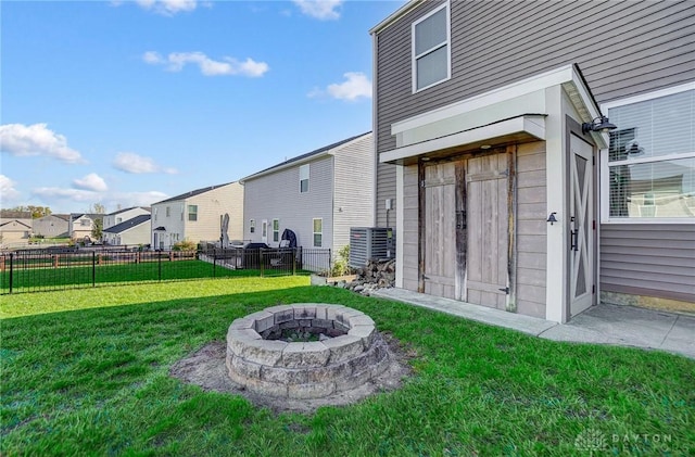 view of yard featuring a residential view, an outdoor fire pit, and fence