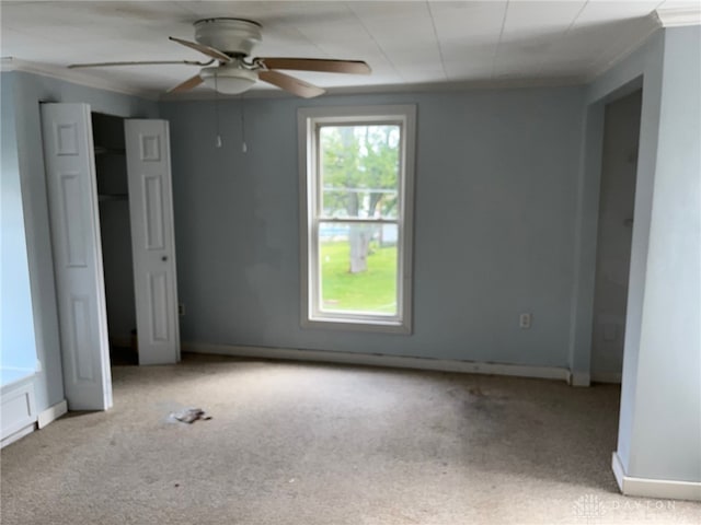 unfurnished bedroom featuring light carpet, crown molding, and ceiling fan