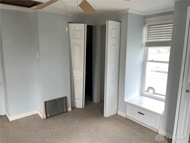 unfurnished bedroom with ornamental molding, light colored carpet, and ceiling fan