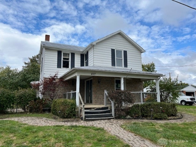 view of front of house with a porch and a front lawn